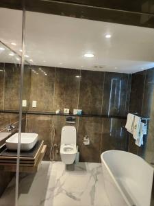 IloraLe Masik Hotel的浴室配有卫生间、盥洗盆和浴缸。