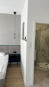 罗兹Kamienica Łódzka的一间卧室设有一张床和一个玻璃淋浴间