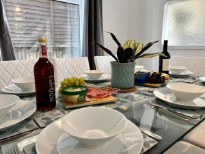 卡迪夫Spacious Family home in great location in Cardiff的玻璃桌,带盘子和一瓶酒