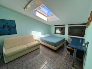 格拉多Appartamento Marchesini的一间卧室配有一张床、一张沙发和一张书桌