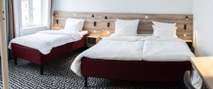哥本哈根Good Morning City Copenhagen Star的客房内的两张床和白色枕头