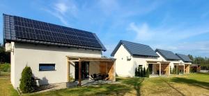 斯沃尔纳加西耶Domki Swornegacie - Sielsko Anielsko的屋顶上设有太阳能电池板的房子