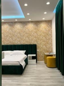 费里Hotel MoonLight的一间卧室设有一张绿色的床和一面墙