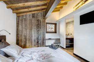 丰罗默奥代洛维亚Chalet nid des écureuils的一间卧室设有一张床和木墙