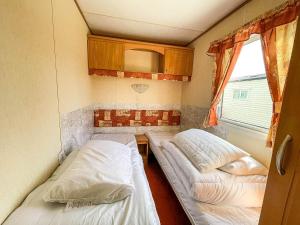赫彻姆8 Berth Caravan For Hire At Heacham Holiday Park In Norfolk Ref 21024f的小房间设有两张床和窗户