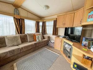 亨斯坦顿Lovely Caravan For Hire With Large Decking Area In Hunstanton Ref 23218k的带沙发和平面电视的客厅