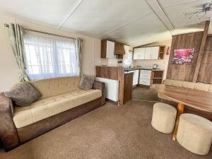 劳斯Lovely 8 Berth Caravan With Decking At Sunnydale Park, Lincolnshire Ref 35091br的带沙发的客厅和厨房