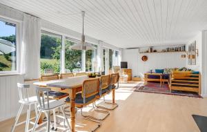 埃贝尔托夫特3 Bedroom Stunning Home In Ebeltoft的用餐室以及带桌椅的起居室。