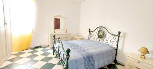 卡斯特尔萨多Beach Apartments Costa dei Venti的一间卧室配有一张床,铺有一个 ⁇ 板地板