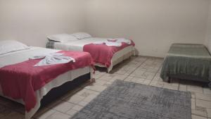 康赛瓦托利亚Pousada dos Girassóis的一间带两张床的卧室,铺有瓷砖地板。