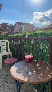 普里什蒂纳Prishtina Guests'的阳台上的木桌和一杯葡萄酒