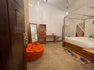 达瓦拉维Amba Kola Udawalawa的一间卧室,配有一张床和一个橙色的衣柜