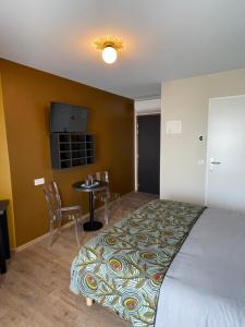 勒阿弗尔Smart Appart Le Havre 105的一间卧室配有一张床、一张桌子和一台电视。