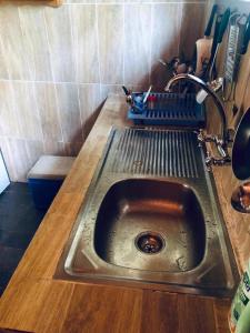 克里比Kribi Trip Experience的厨房里的一个金属水槽,带有木台