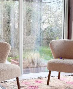 福松布罗内Agriturismo "Le Cannelle" spa & day wellness的两把椅子坐在窗前