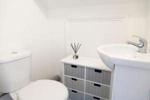 伦敦5 Bed Luxury London Home的白色的浴室设有卫生间和水槽。