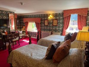 阿利士皇家天地酒店的一间带两张床和一张书桌的卧室以及一间客房