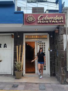 莫克瓜Hostal COLUMBIA的站在餐厅门口的女人
