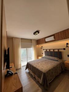 Las FloresTERMAS PISMANTA Hotel & Spa的一间卧室配有一张床和一台电视