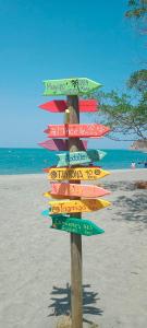 圣玛尔塔Playa del Ritmo Beach Hostel & Bar - Adults Only的海滩上与海洋的方向标志