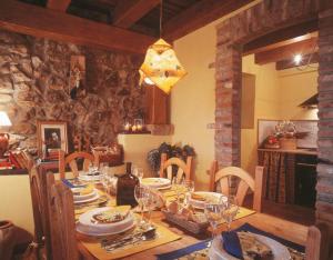 Robledo de la GuzpeñaLa Venta Del Alma的用餐室配有带盘子和酒杯的桌子