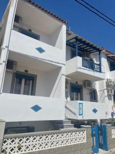 斯卡拉埃雷索Pansion Katerina的白色的建筑,设有蓝色的门窗