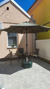 扎耶查尔Apartman Arsić Zajecar的露台的遮阳伞、两把椅子和一张桌子