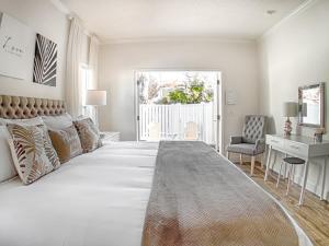 圣奥古斯丁Private Romantic Retreat Mins DWTN Beach的一间白色的大卧室,配有一张大床和一张书桌