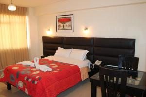 塔克纳Hotel Reggia的酒店客房,配有一张带红色毯子的床