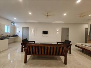 钦奈SAIBALA HOMESTAY - AC 5 BHK NEAR AlRPORT的客厅设有长凳和墙上的电视