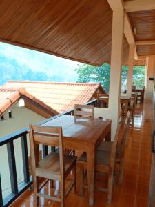 NongkhiawCam U View Bungalow的阳台的用餐室配有桌椅