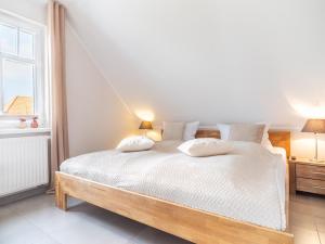 欧巴德伍斯图Haus STRANDLUST WF-05的卧室配有一张带两个枕头的大白色床