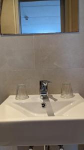 法尔肯堡Hotel 1711的浴室水槽,配有2个玻璃杯和镜子