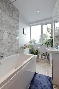 Horsell30 Woodlands的白色的浴室设有浴缸和水槽。