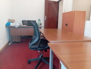 内罗毕Park Place Business Center的一个带桌子和黑椅的办公室隔间