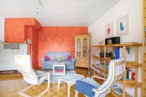 GerstettenBikerhäusle的客厅配有蓝色的沙发和两把椅子