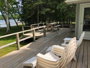 HonorNew! Birch Cove Bungalow - Gorgeous Lakefront!的房屋内带长椅和野餐桌的甲板