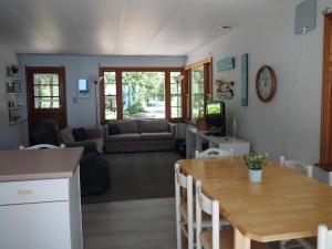 HonorNew! Birch Cove Bungalow - Gorgeous Lakefront!的厨房以及带木桌的起居室。