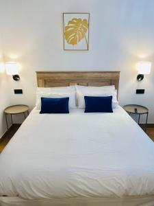 梅里达El Parador del César的卧室内的一张带蓝色枕头的大型白色床