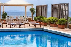 希俄斯希尔斯尚德里酒店的一个带桌椅的海洋游泳池