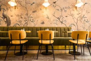罗马维米纳勒酒店的餐厅设有黄色的椅子和鲜花墙