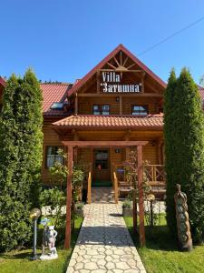米库利钦Villa "Затишна"的一座木结构建筑,上面有读取胜峰的标志