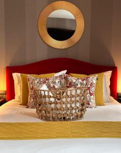 里昂亚历山德拉酒店的一张带红色床头板的床,配有枕头和镜子