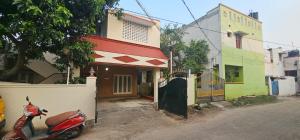 钦奈SAIBALA HOMESTAY - AC 3 BHK NEAR AlRPORT的停在大楼前的一辆红色摩托车