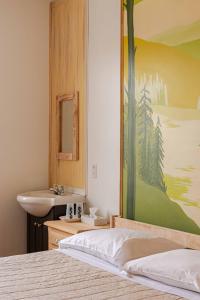 拉马巴耶La Secousse的卧室设有水槽,墙上挂有绘画作品