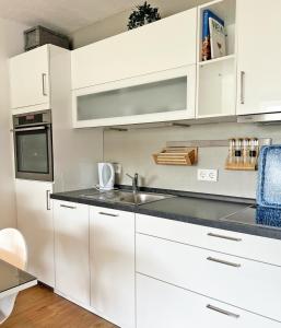 格洛米茨Driftberg 1 Whg 18的厨房配有白色橱柜和水槽