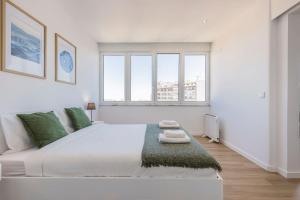 里斯本Eua 112的白色卧室设有一张大床和两个窗户