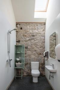 布莱辛顿June Blake's Garden的浴室配有白色卫生间和石墙。