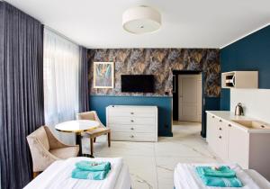索波特Meduza Sopot的一间卧室配有两张床、一张桌子和一台电视。