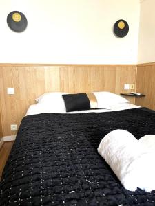 瑟堡德拉卡尔酒店的一张带黑色毯子和两个枕头的床